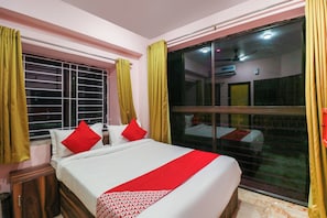 A hotel room with a bed, a window with curtains, and a view of the outside. - Collection O NEOSTAY TOWN HOUSE (Baruipur)
