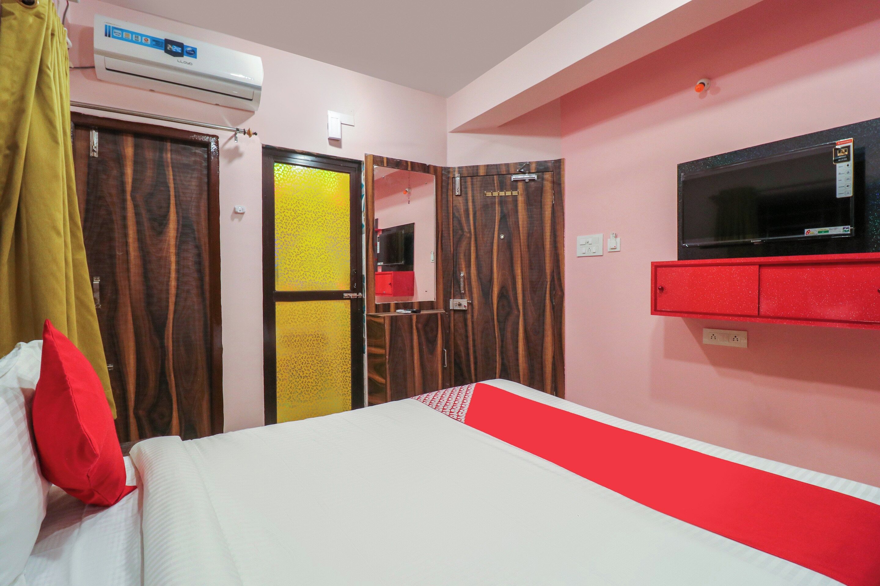 Una habitación de hotel con una cama, televisión, armario y aire acondicionado.