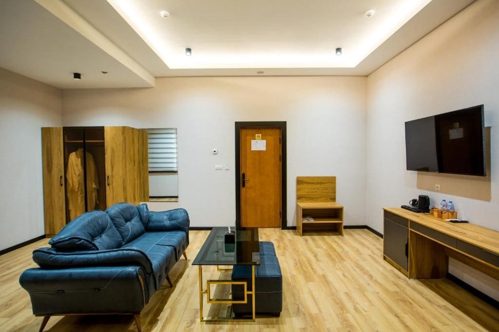 Una sala de estar moderna con un sofá, una mesa de centro, un televisor y un mueble de madera.