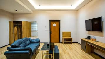 Una sala de estar moderna con un sofá, una mesa de centro, un televisor y un mueble de madera.
