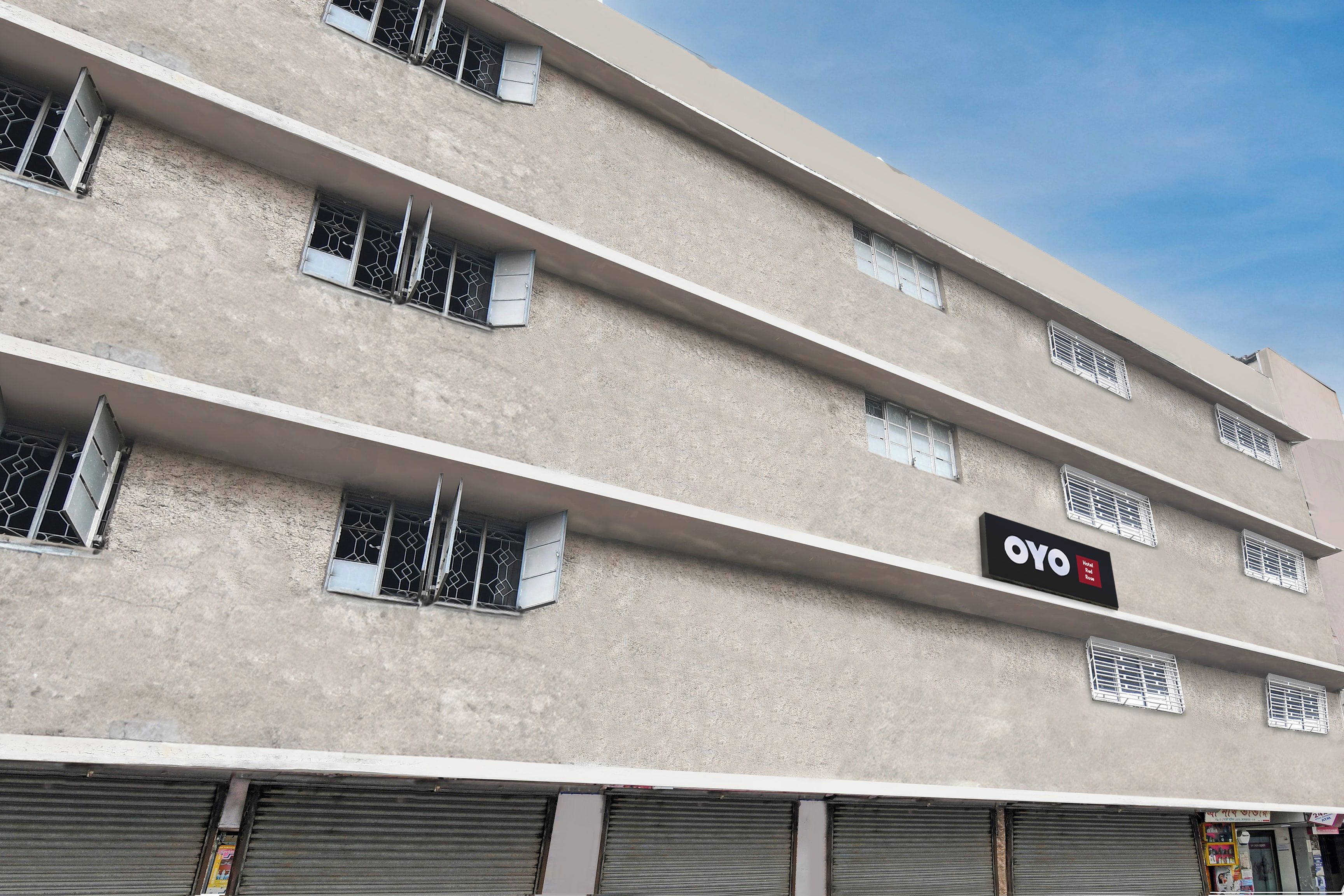A multi-story building with a sign for 'OYO Hotel Red Rose' indicating a hotel presence.