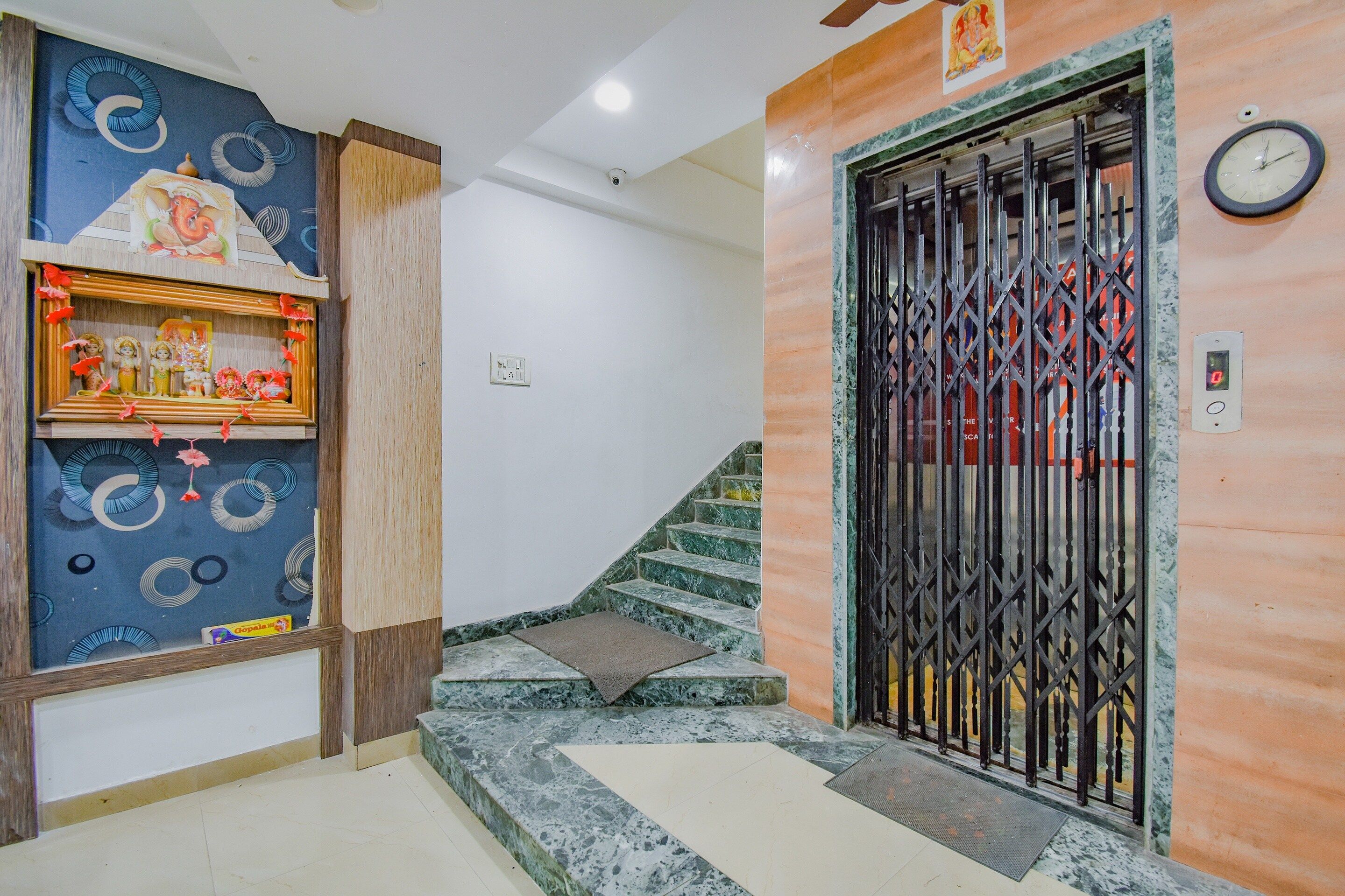 A staircase with a marble finish leading to a door with a metal gate.