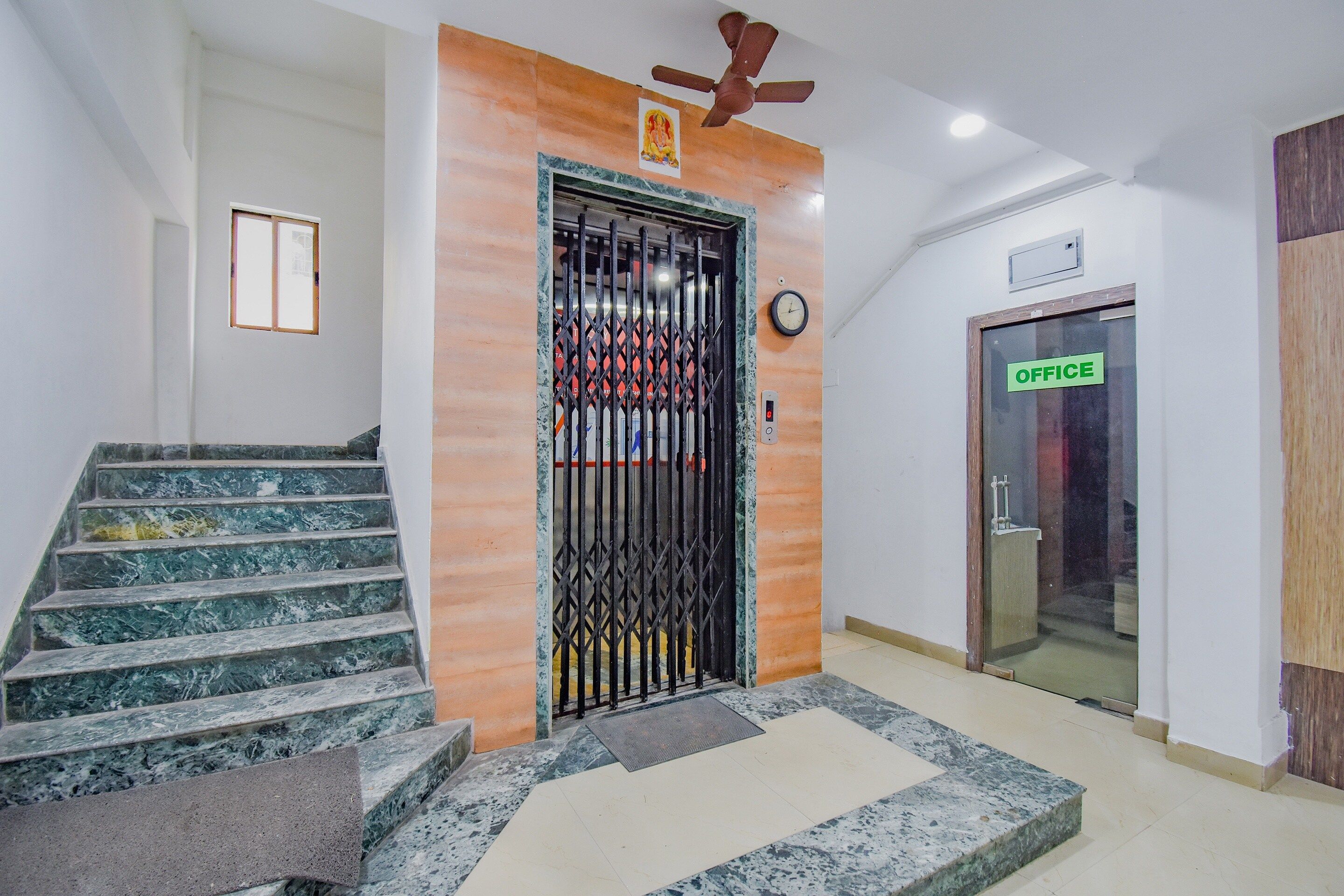 A staircase with marble steps leading to a door with a metal gate.