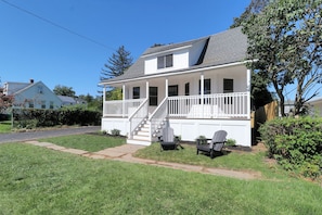A two-story house with a front porch, a staircase, and two Adirondack chairs. - Fairfield -Charming Completely Renovated 3-bedroom house with AC & 2 car garage. (Fairfield)