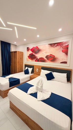 Ein Hotelzimmer mit zwei Betten, einem großen Blumenbild an der Wand und einem Holzschrank.