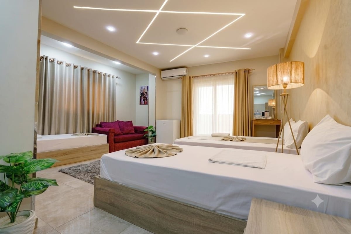 Ein Hotelzimmer mit einem Bett, einem Nachttisch, einer Lampe und einer Pflanze.