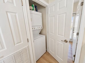 A laundry room with a washer and dryer, a door, and a vent. - Las Flores #B Spacious 2/2 W/Easy Beach Access (South Padre Island)