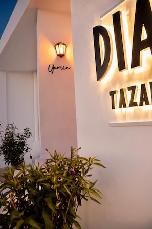 Un edificio con letreros iluminados que dicen 'DIANA' y 'Tazara'.