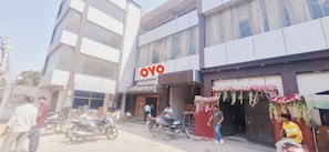Un edificio con un llamativo letrero 'OYO', que indica un hotel o alojamiento.