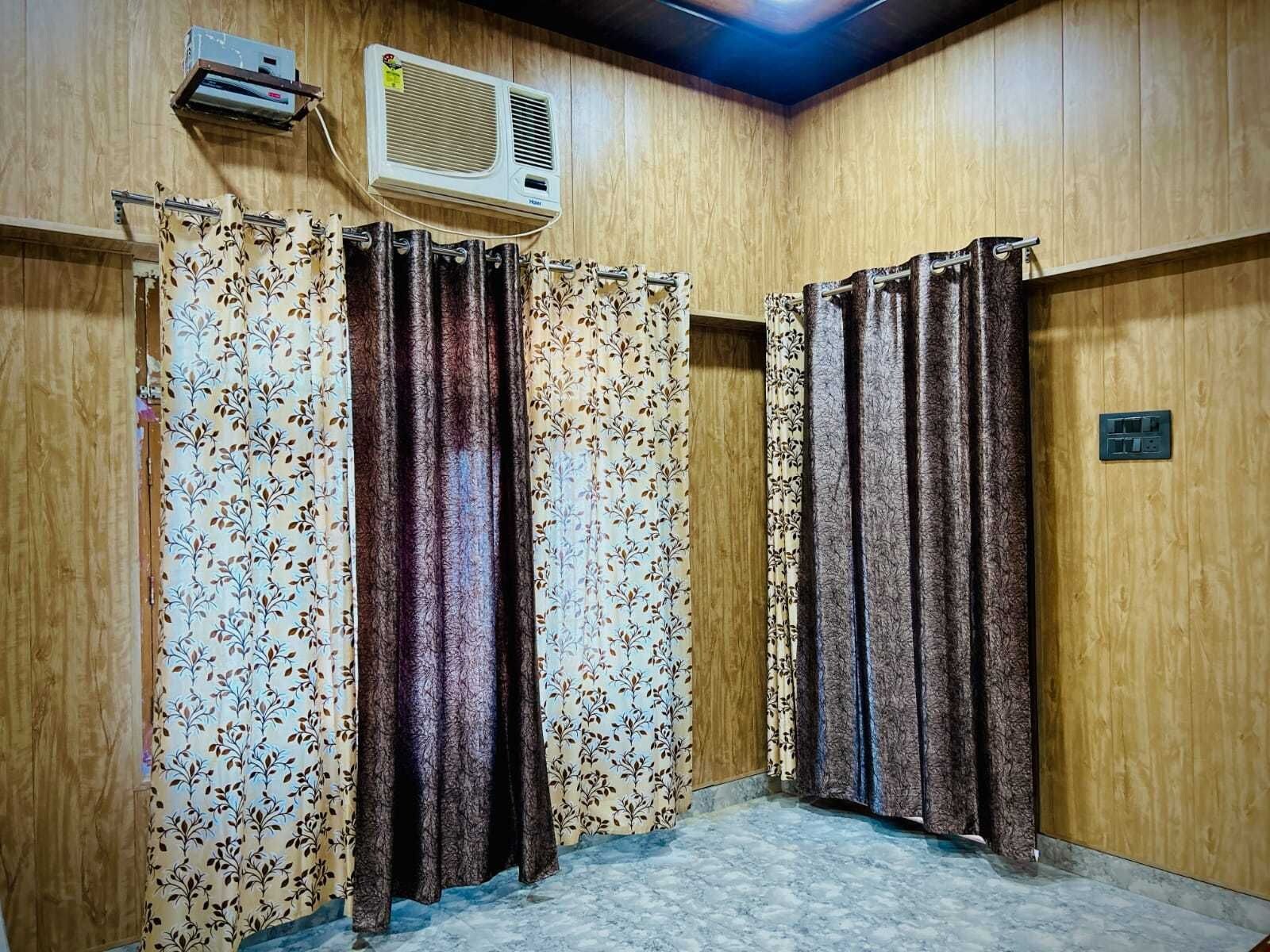 Una habitación con paredes de madera, un ventilador de techo y una zona de ducha con cortinas.