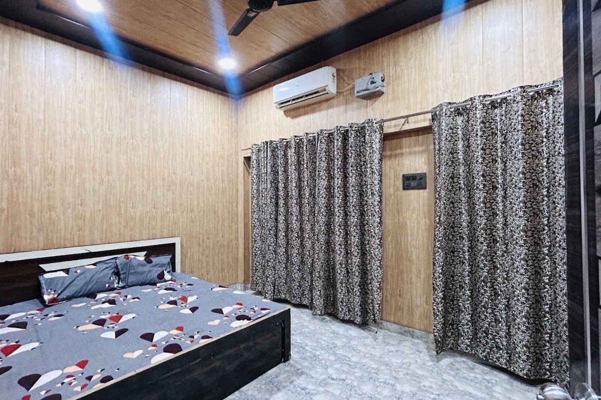 Un dormitorio con cama, cortinas, aire acondicionado y ventilador de techo.