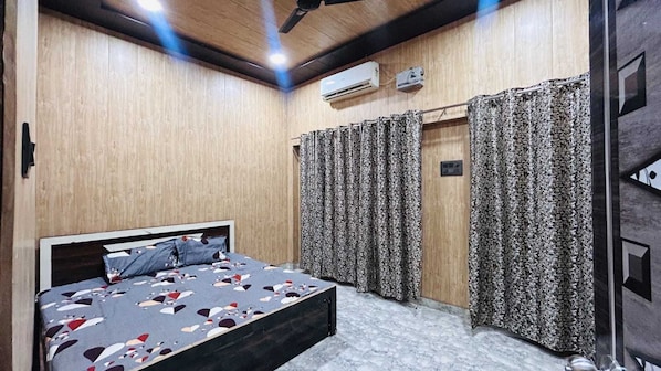 A bedroom with a bed, curtains, an air conditioning unit, and a ceiling fan. - Hotel O Shri Krishna place (Lakhimpur)