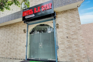 A hotel entrance with a sign reading 'HOTEL R.K STAY' and 'LUXURIOUS ROOMS'.