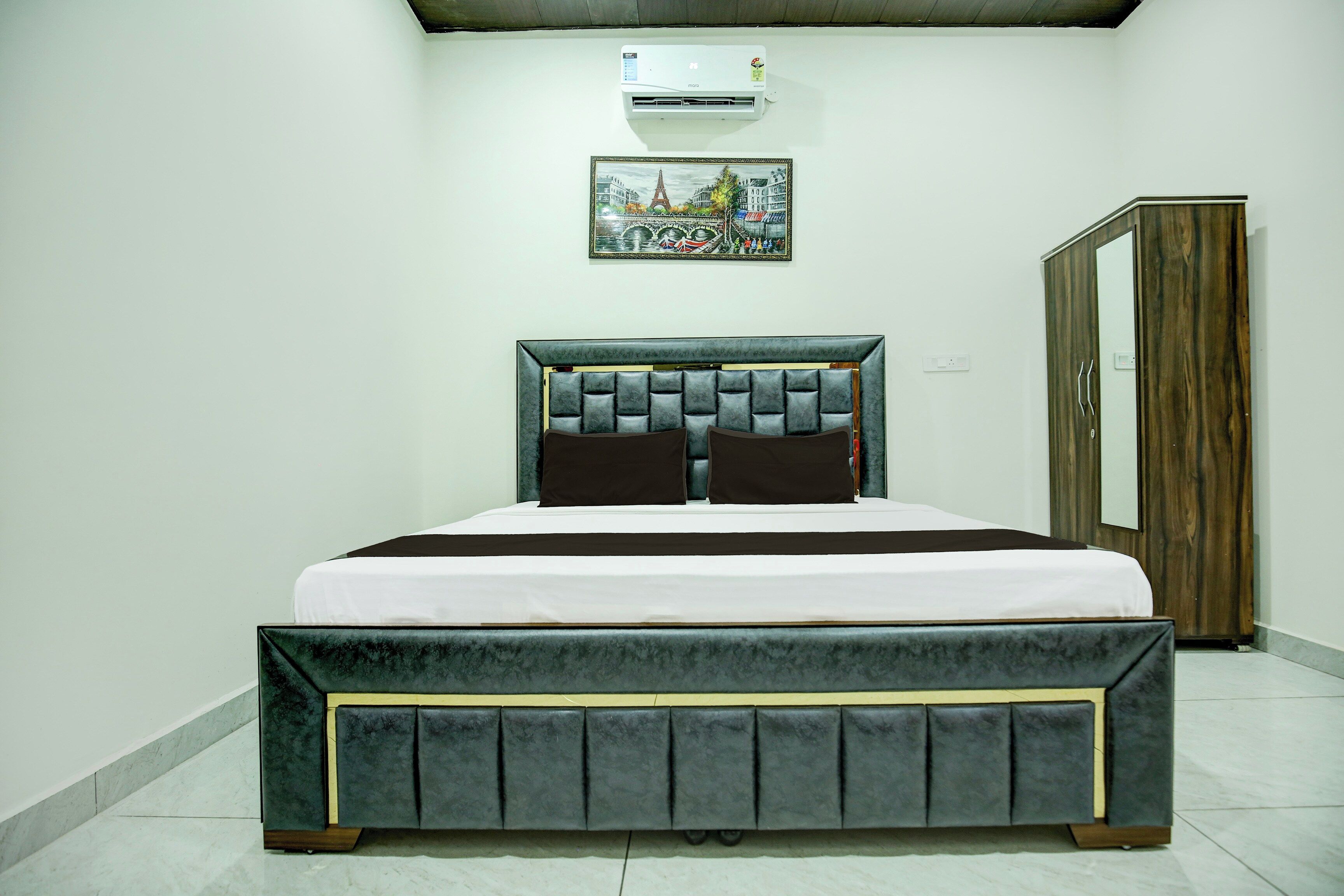 Quarto com cama, guarda-roupa e ar condicionado fixado na parede.
