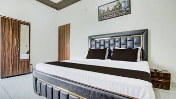 Un dormitorio con una cama grande, un armario de madera y un cuadro en la pared.