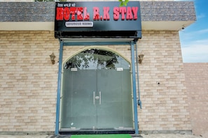 A hotel with a sign that reads 'HOTEL R.K STAY' and 'LUXURIOUS ROOMS' above a closed shutter door. - Hotel O by OYO R.K STAY (Ludhiana)