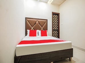 A bed with a headboard, pillows, and a bedspread. - Hotel O by OYO Sunrise (Ludhiana)