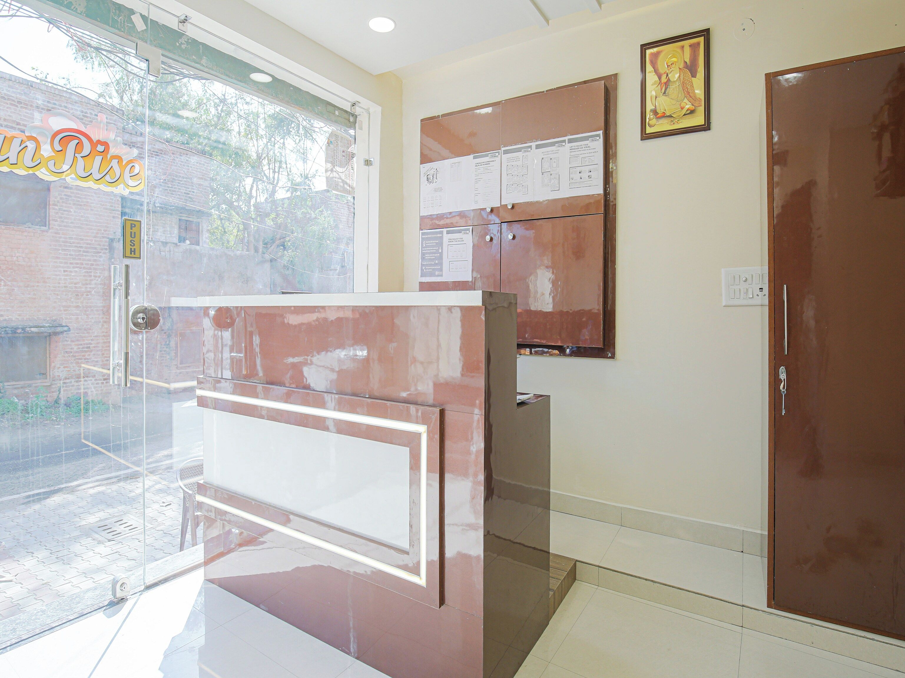 A reception area with a glass door, a bulletin board, and a closed door.