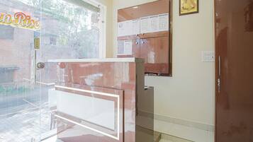A reception area with a glass door, a bulletin board, and a closed door.