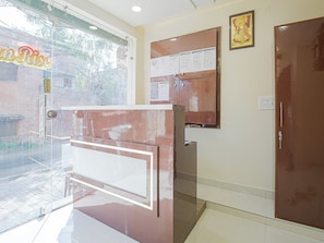 A reception area with a glass door, a bulletin board, and a closed door. - Hotel O by OYO Sunrise (Ludhiana)