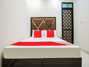 A bed with a headboard, white bedding, and red pillows. - Hotel O by OYO Sunrise (Ludhiana)