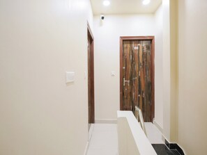 Un pasillo con una puerta marcada con el número 401, una pared blanca y un interruptor de luz.