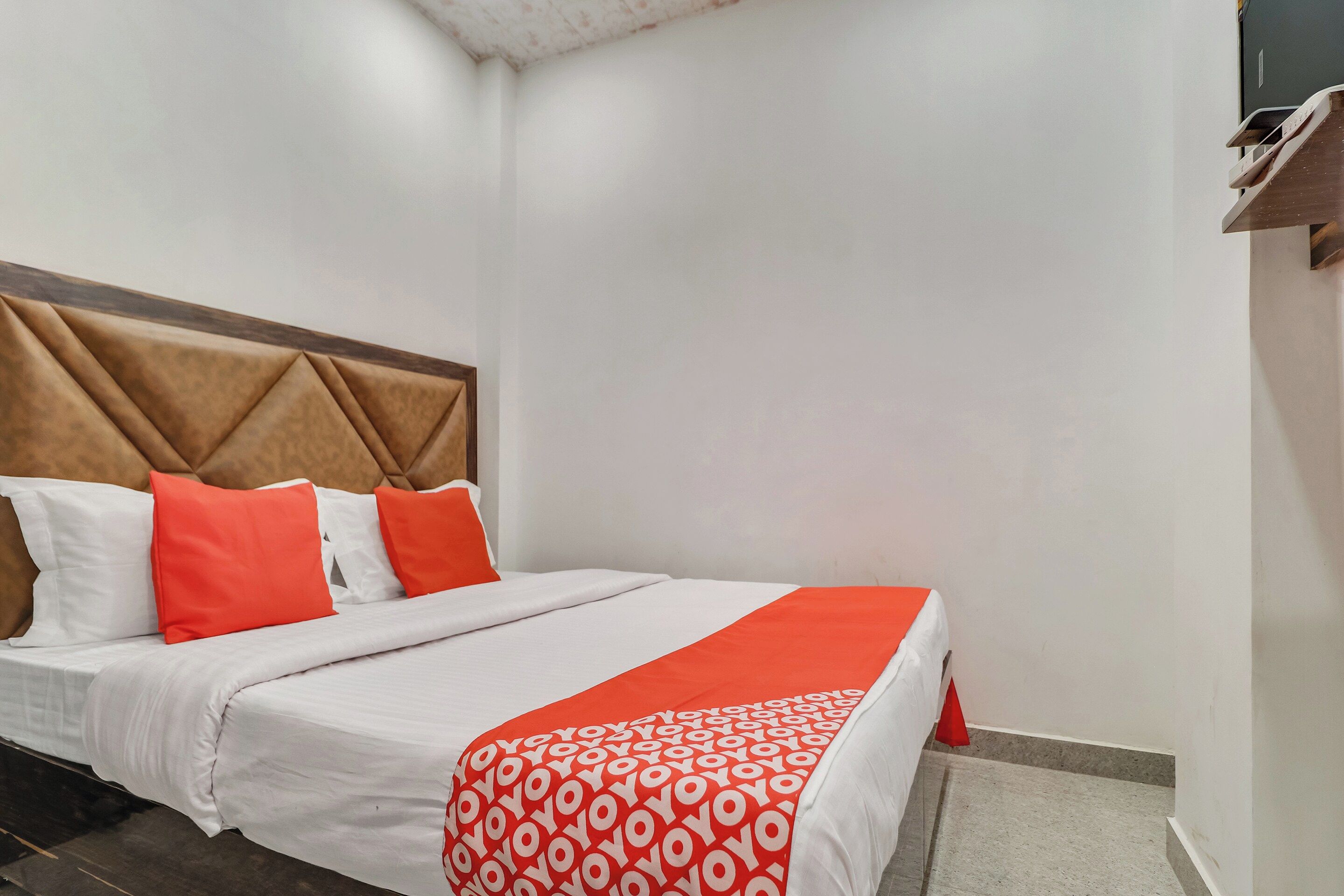 Una habitación de hotel con una cama, almohadas y cabecero.