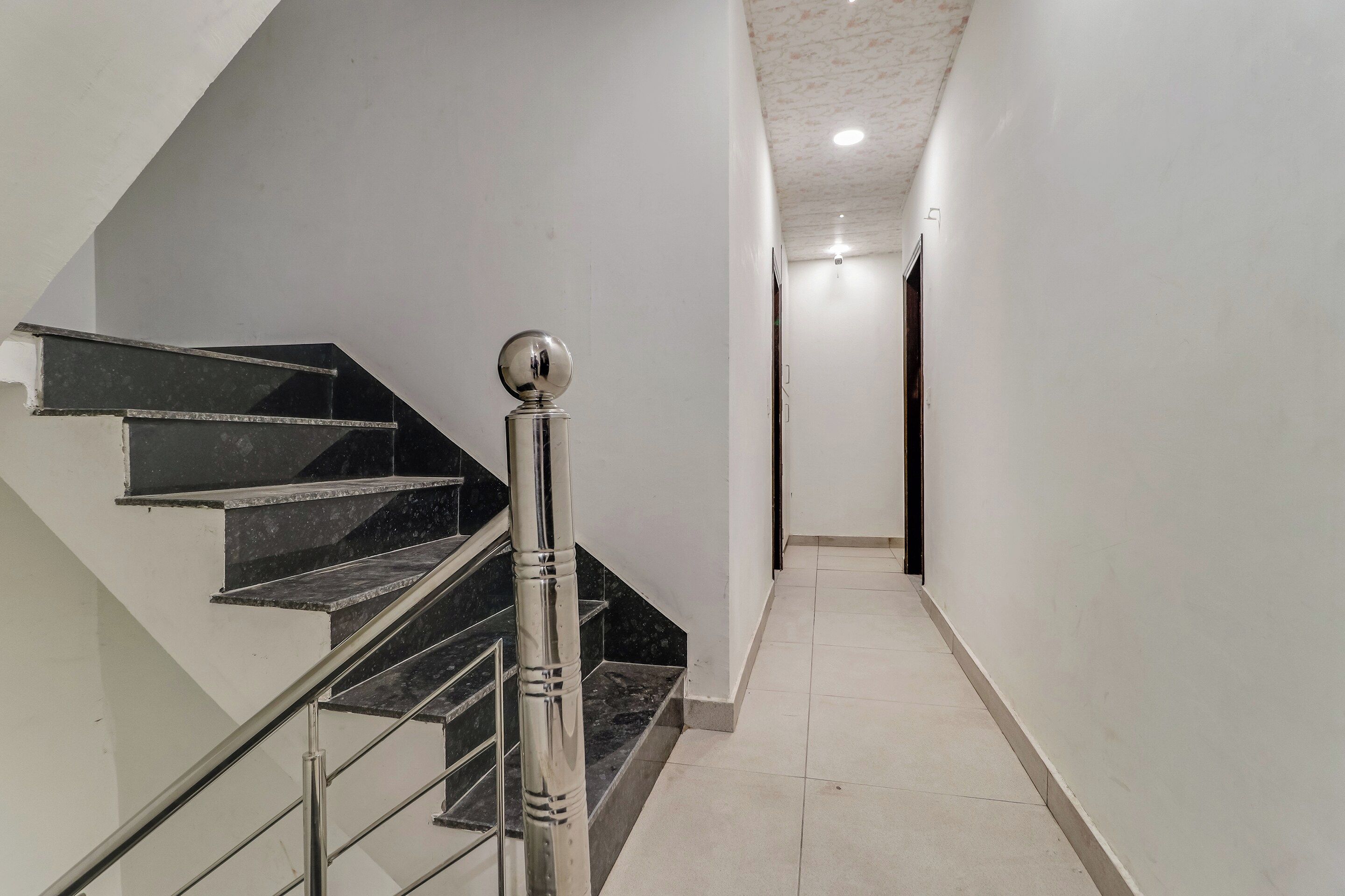 Una escalera con barandilla de metal y peldaños negros que conducen a una plataforma.
