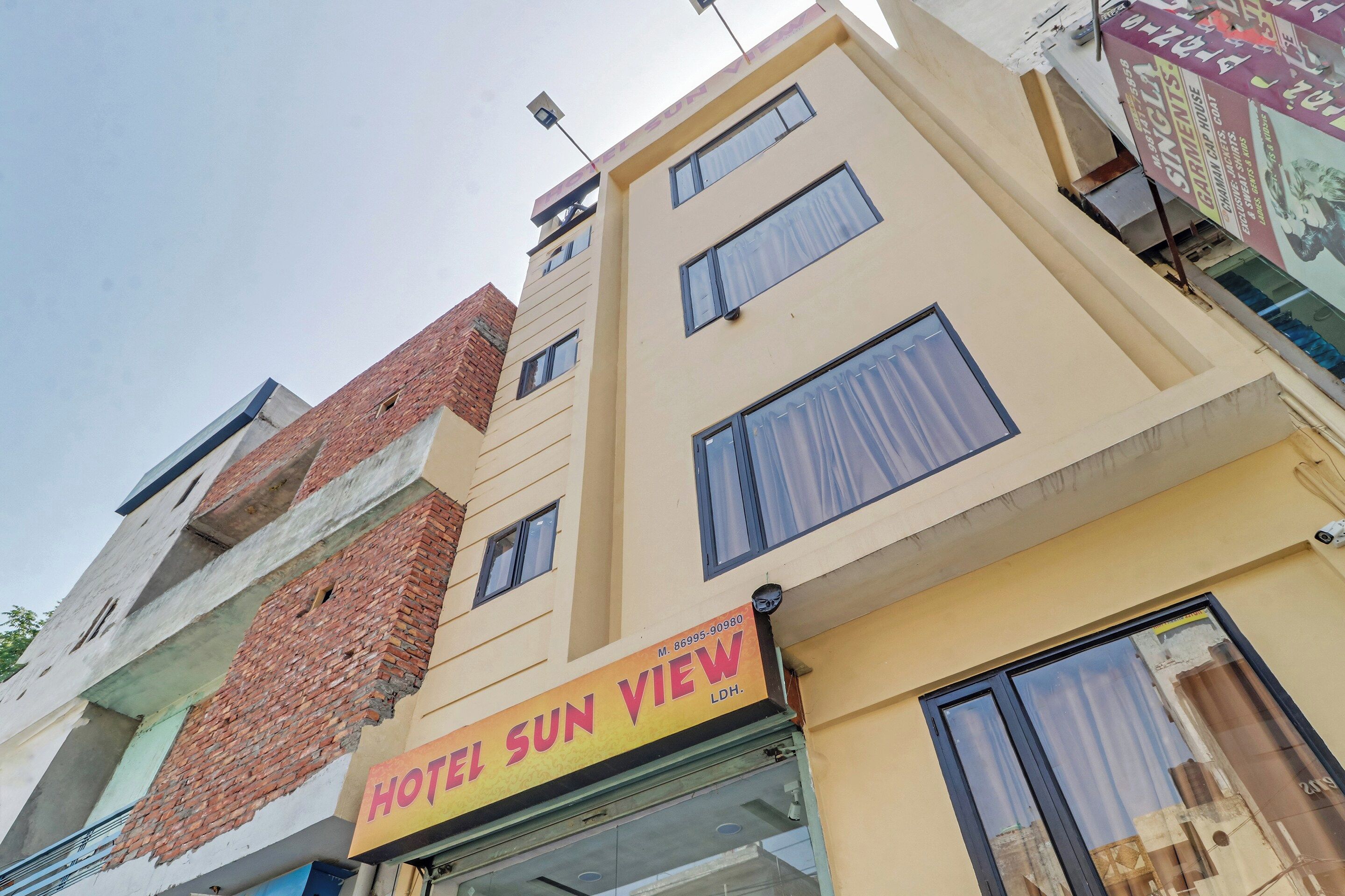 Um edifício com vários andares e uma placa indicando 'HOTEL SUN VIEW', identificando-o como um hotel.