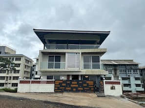 A multi-story building with a flat roof, large windows, and a gated entrance.