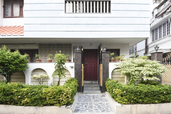 A building with a red door, a balcony, and potted plants. - Hotel O Smriti Villa (Bidhannagar)