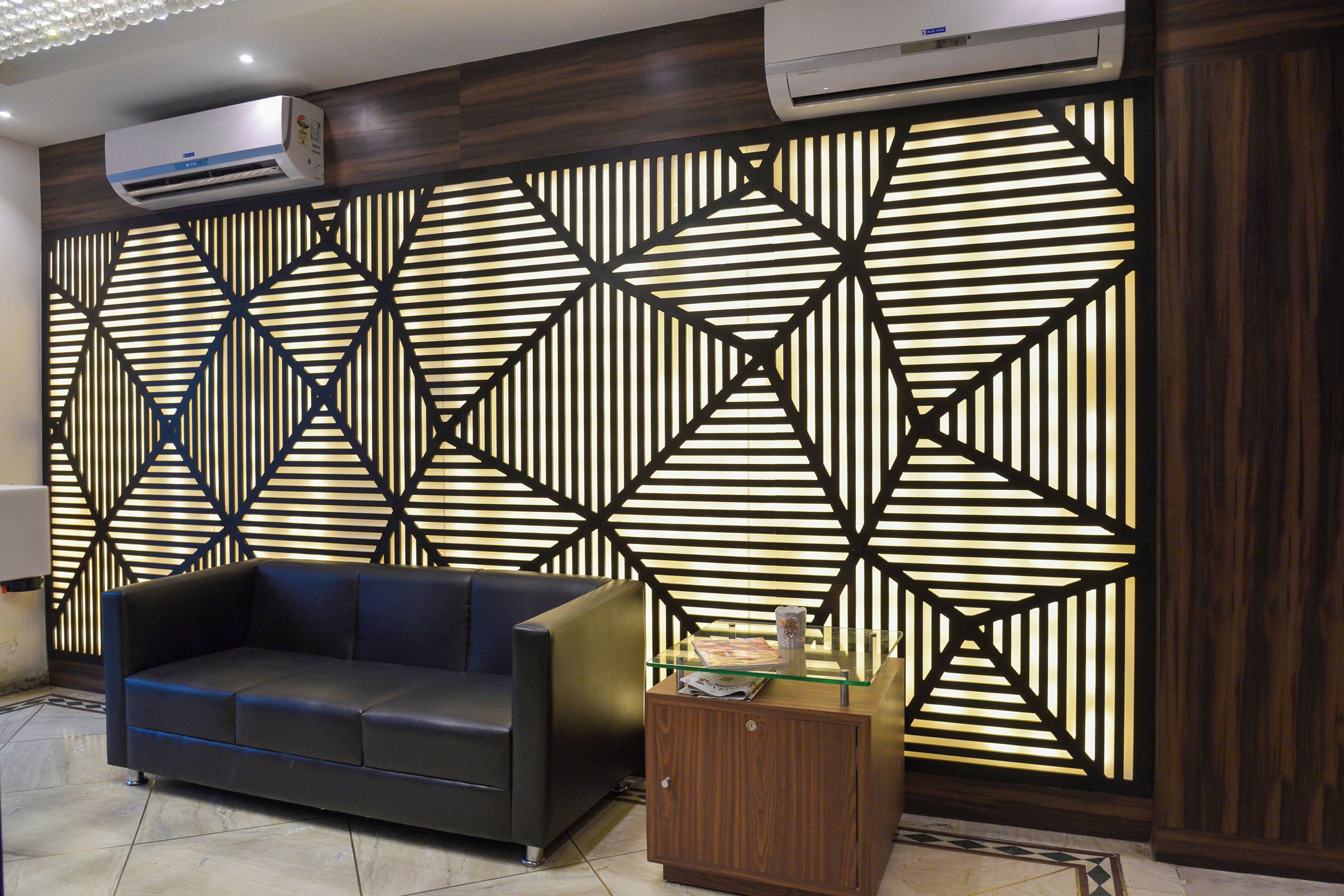 Una sala de estar moderna con un muro estampado con motivos geométricos, un sofá de cuero y un aparador de madera.