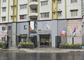 A hotel with a modern facade, multiple balconies, and a gated entrance.