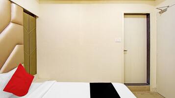 Una habitación de hotel con una cama, una puerta y una pared.