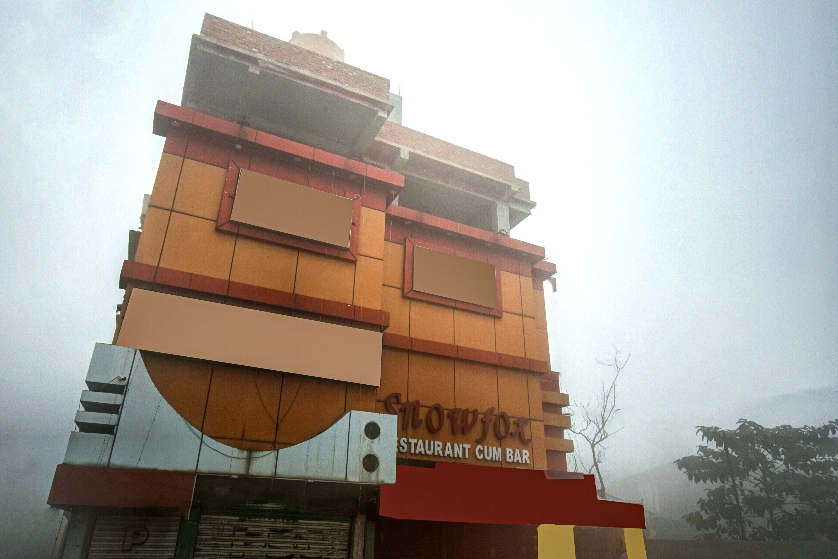 Un edificio de varios pisos con un letrero que dice 'Restaurant Cum Bar' a nivel de la calle.