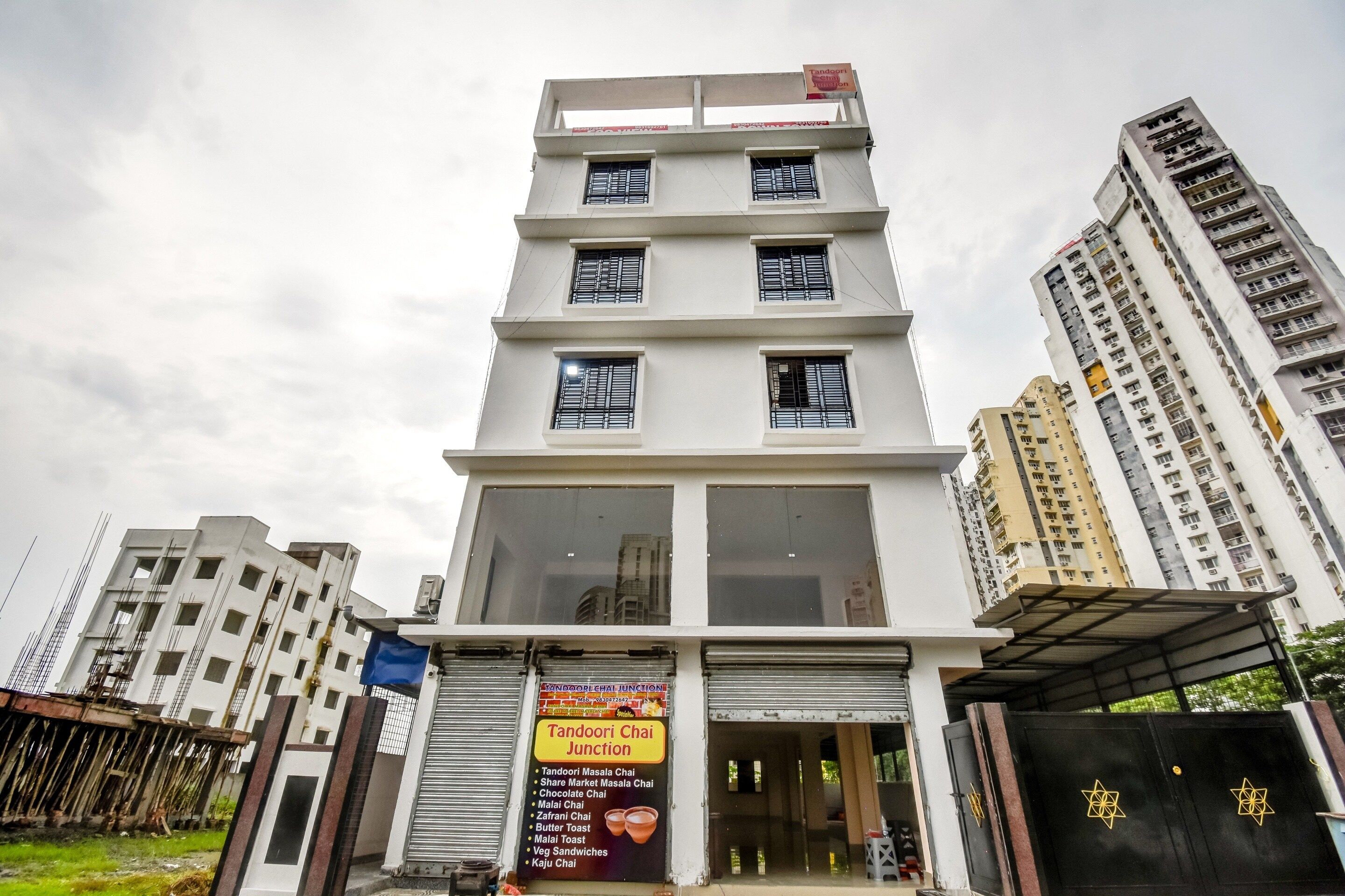 A multi-story building with a signboard advertising a food outlet.