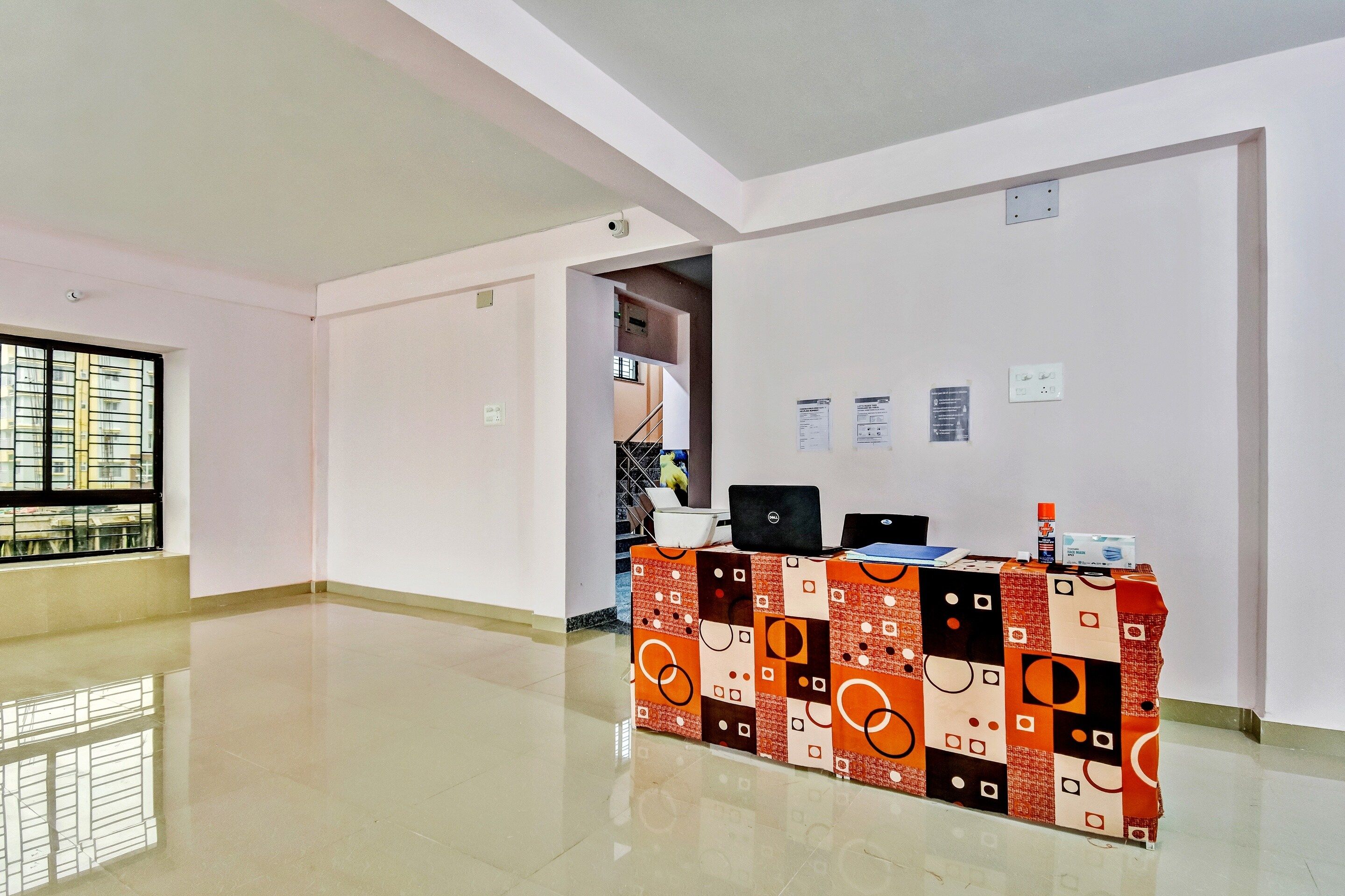 A reception area with a desk, computers, and informational posters on the wall.