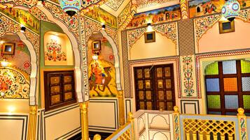 A traditional interior with ornate arches, a staircase, and decorative lighting.