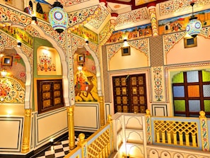 Ein traditionelles Interieur mit aufwendigen Bögen, einer Treppe und dekorativer Beleuchtung.