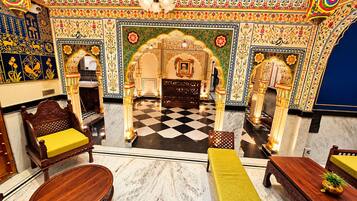A room with a checkered floor, ornate walls, and traditional furniture.