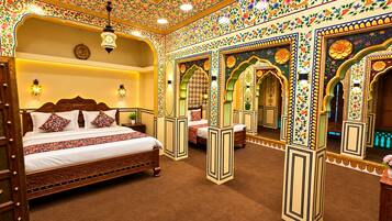 Une chambre de style traditionnel, dotée d’un grand lit, de murs richement décorés et d’un plafond orné.