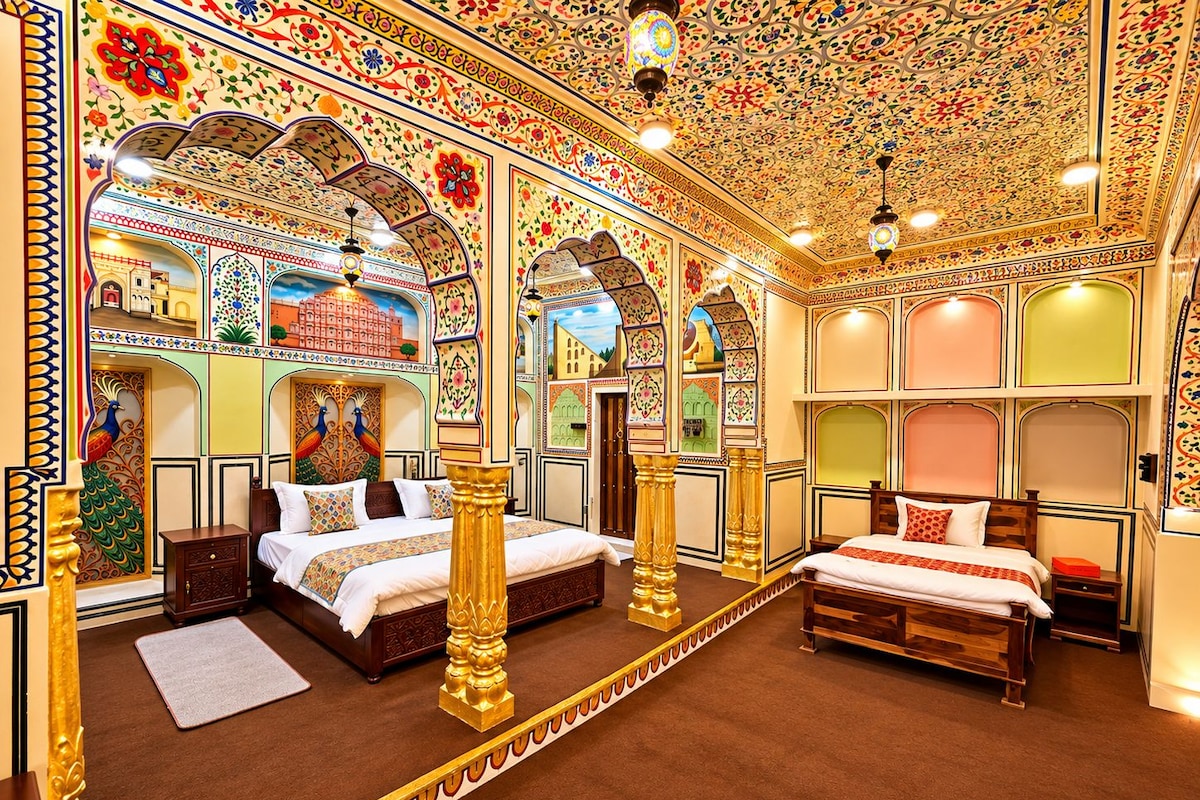 A room with two beds, ornate ceiling, and detailed wall decorations.