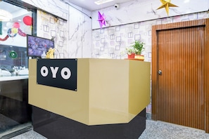 En receptionsdisk med en skylt som visar texten ”OYO” i en hotellobby.