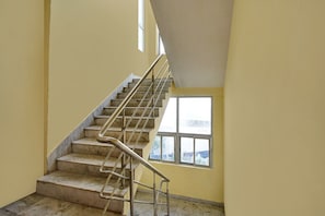 Un escalier avec des rampes métalliques menant à un palier.
