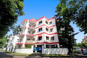 Un immeuble à plusieurs étages doté de balcons, d’une entrée sécurisée et d’une enseigne indiquant qu’il s’agit d’un hôtel.