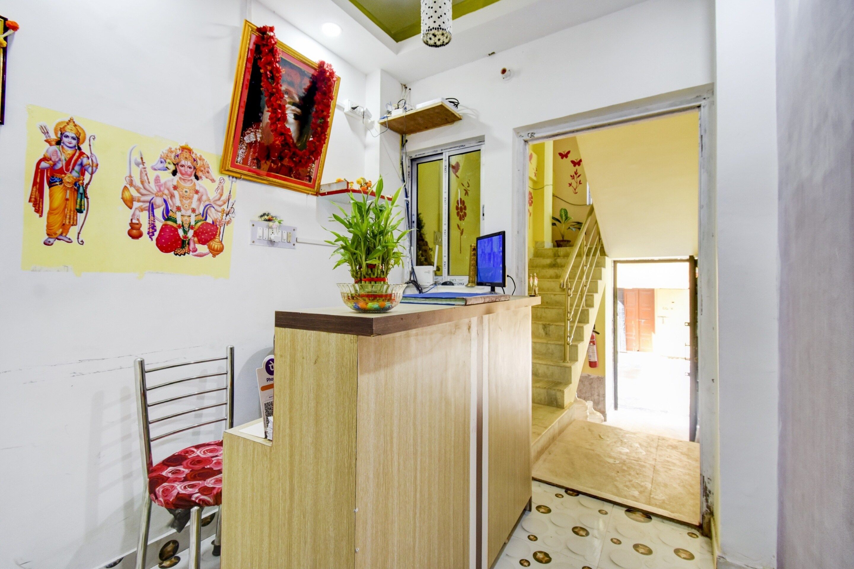 A reception area with a desk, chair, and a potted plant.