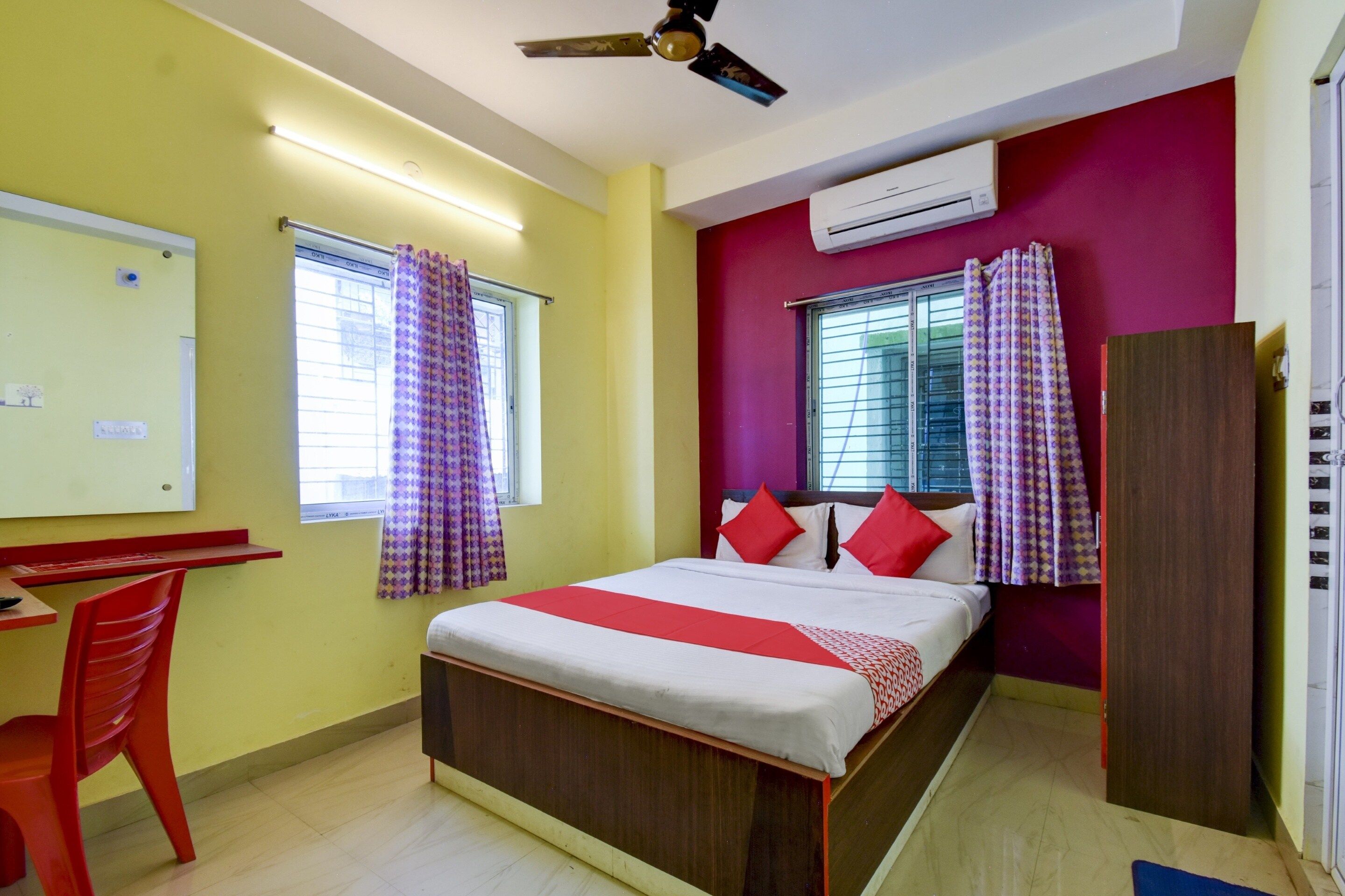 A room with a bed, a desk, a chair, and a wardrobe.