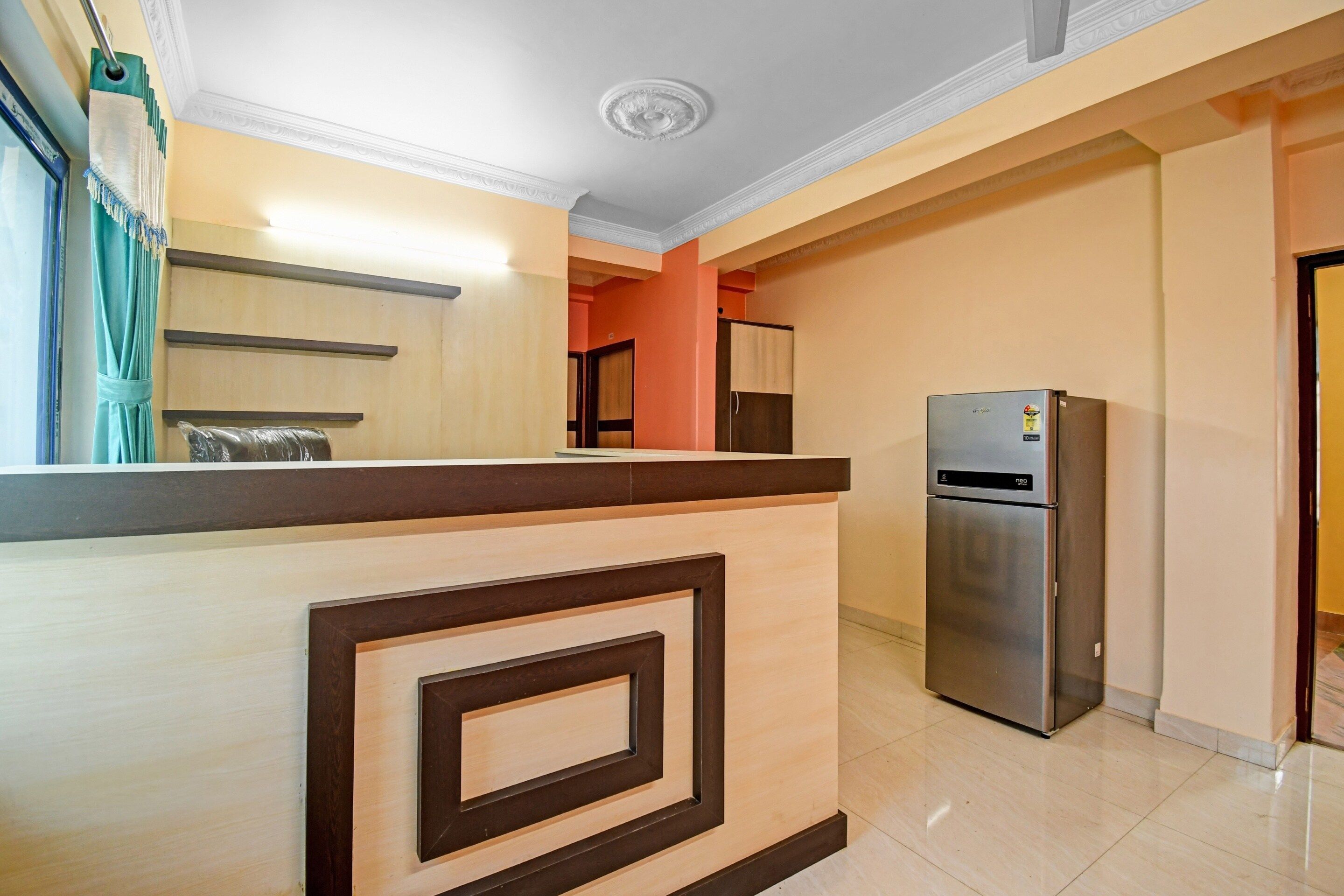 A modern kitchen with a built-in refrigerator, a wooden counter, and a view into the adjacent room.
