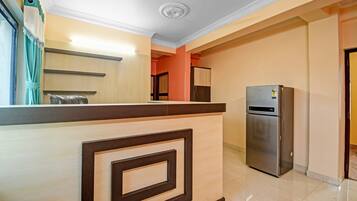 A modern kitchen with a built-in refrigerator, a wooden counter, and a view into the adjacent room.