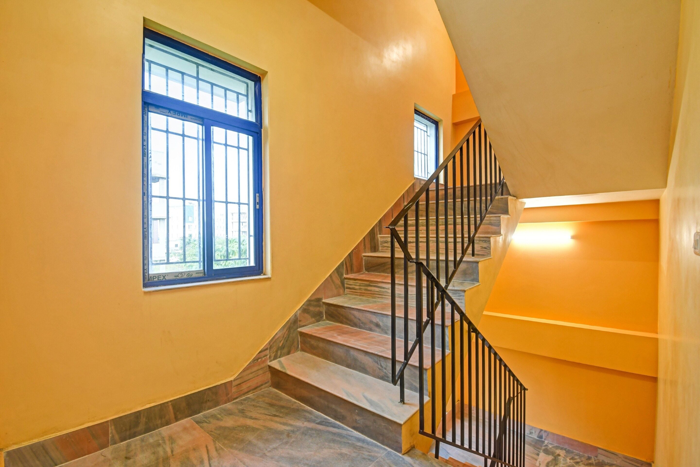 A staircase with a black metal railing leading to a landing.